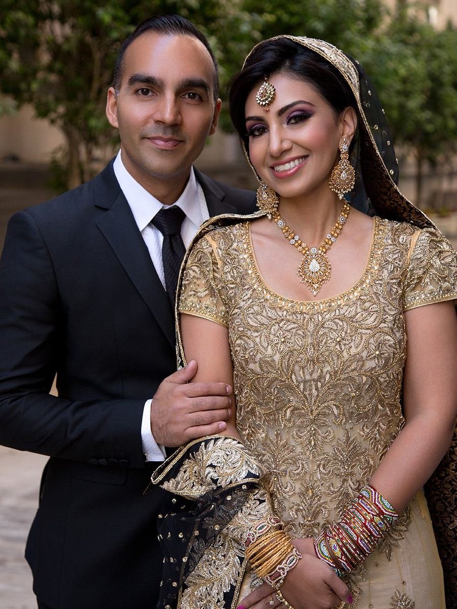 Bride in a gold embroidered gown beside her groom in black tie, downtown Los Angeles wedding