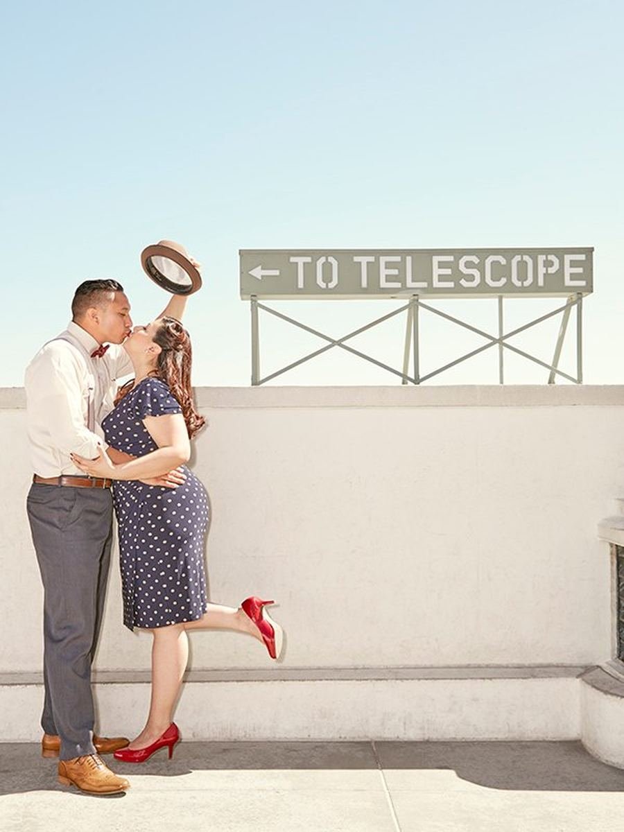 Couple kissing beneath the To The Telescope sign at Griffith Observatory in Los Angeles